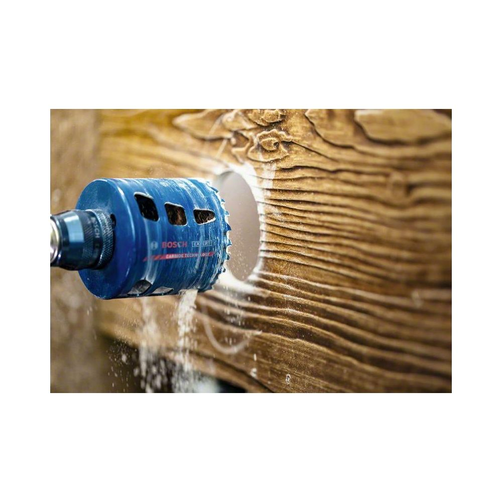 Niebieska otwornica Bosch wierci otwór w drewnie.