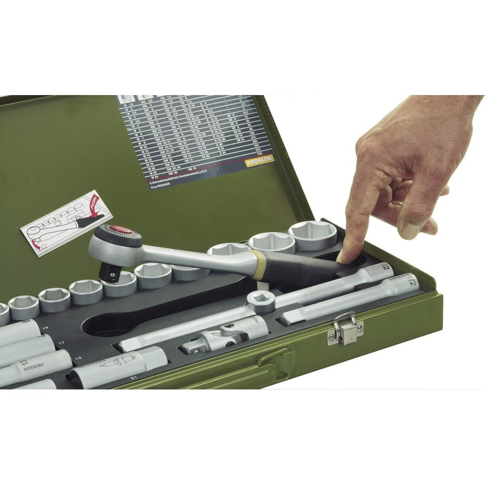 Eine Hand greift in einen grünen Werkzeugkasten mit Steckschlüsseln und Ratsche.
