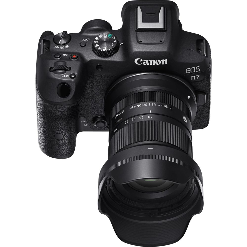 Appareil photo Canon EOS R7 noir avec objectif Sigma 18-50mm, vue en angle.