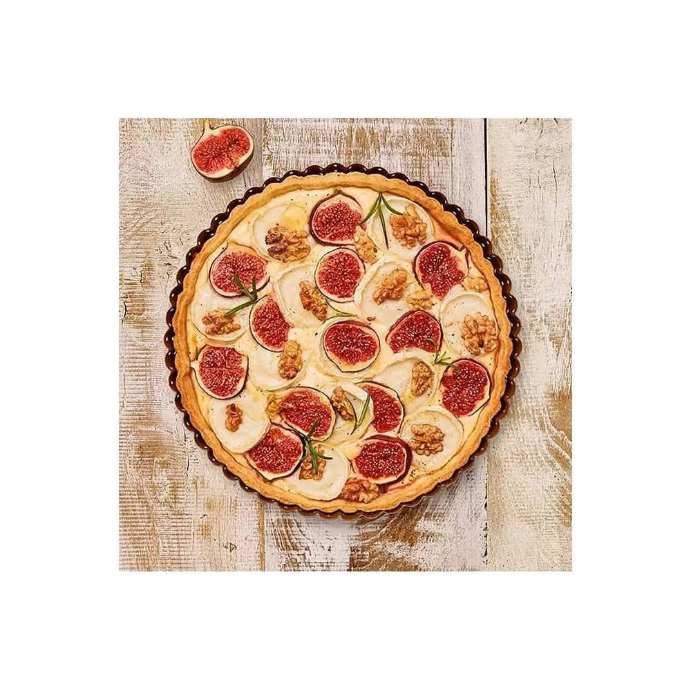 Runde Tarte mit Feigen, Ziegenkäse, Walnüssen und Rosmarin auf Holztisch.