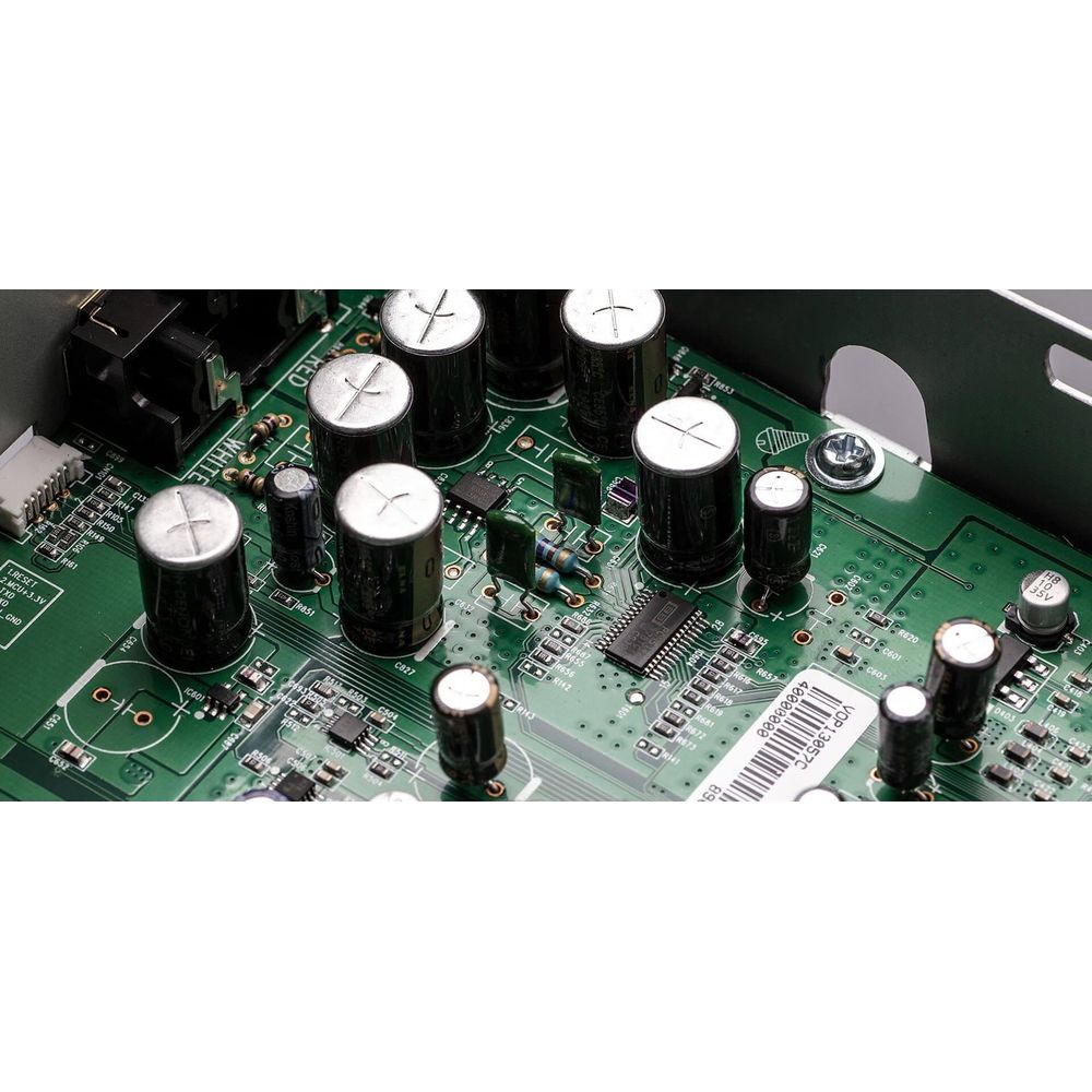 Una placa de circuito verde con muchos condensadores, chips y resistencias.