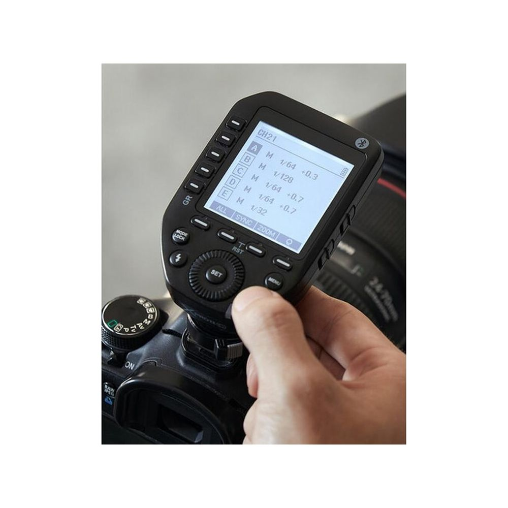 Une main tient une télécommande de caméra noire avec un écran.