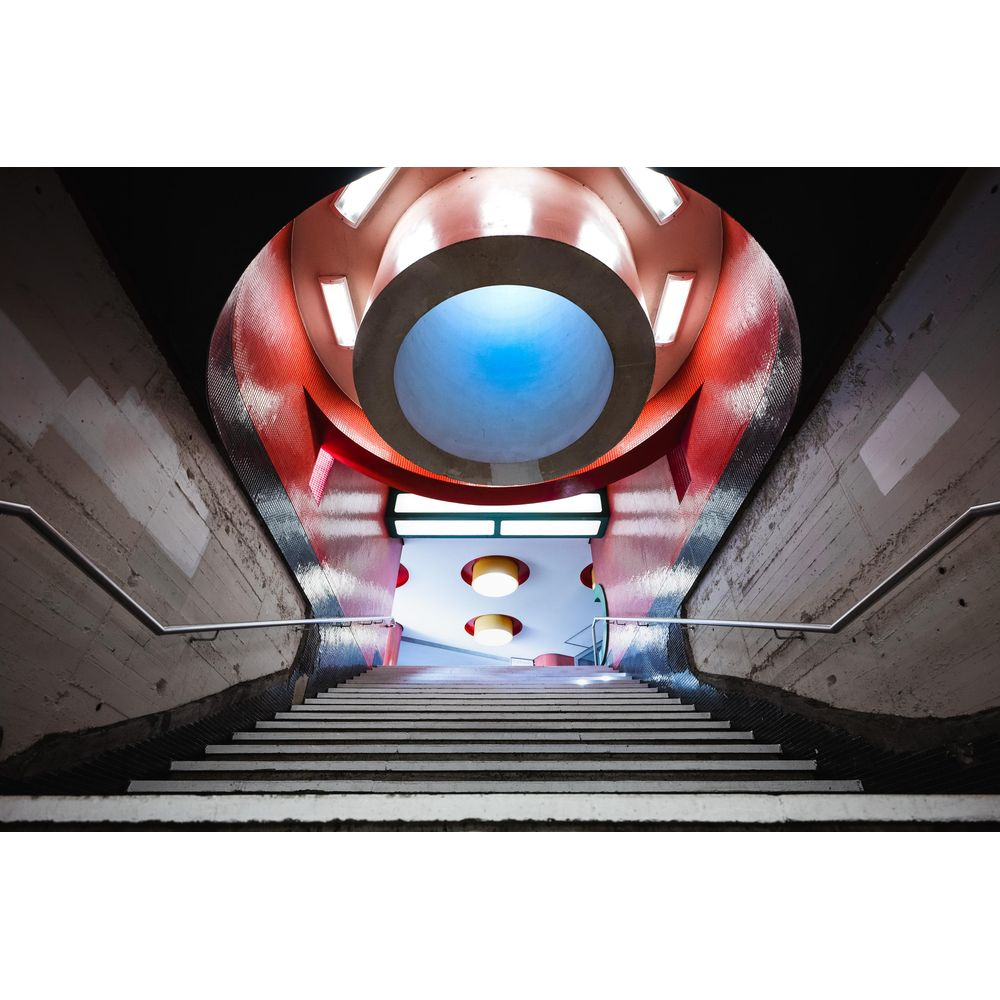 Betonowe schody w futurystycznym budynku z czerwonym i niebieskim oświetleniem.