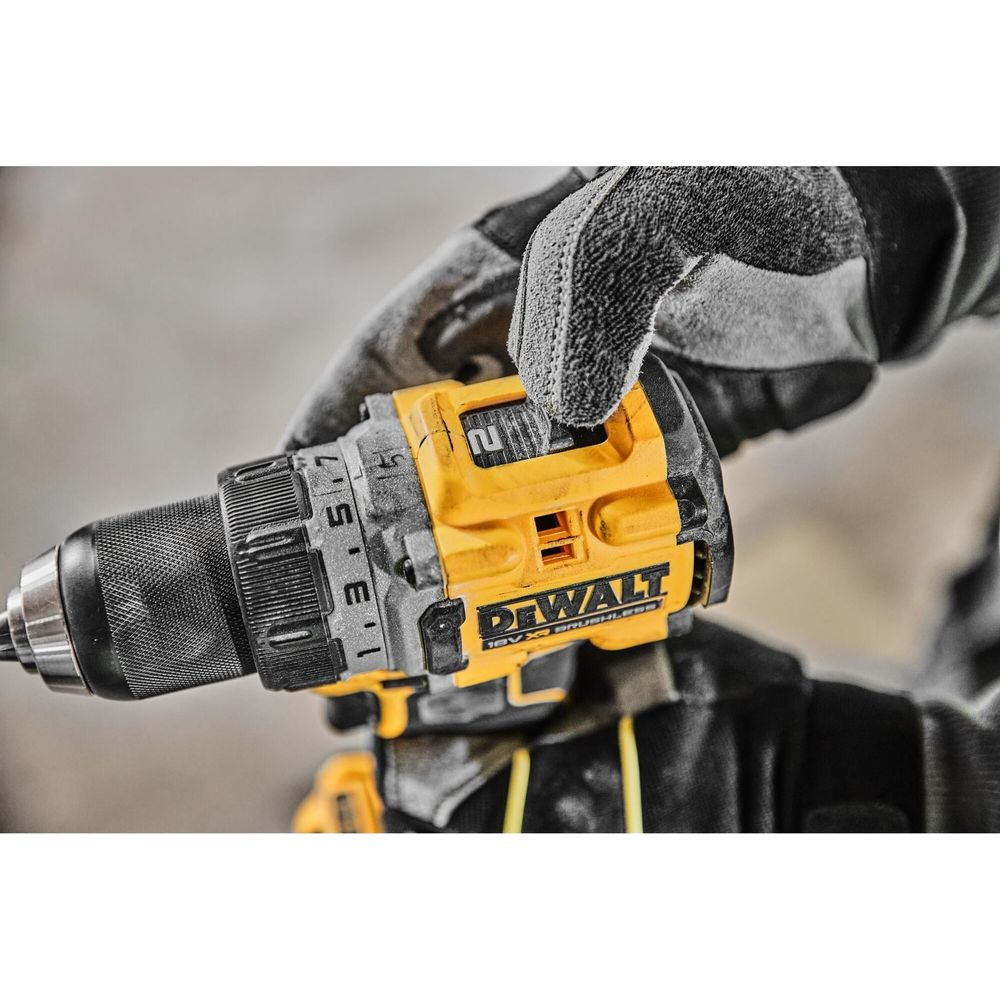 Perceuse DeWalt jaune avec réglage "2", tenue par une main gantée.