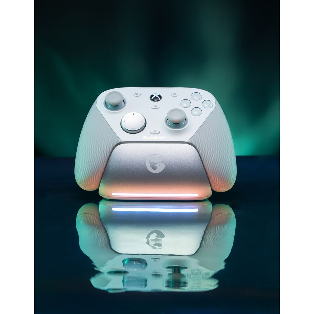 Un controller da gioco bianco e grigio si trova su una base di ricarica con luci colorate.