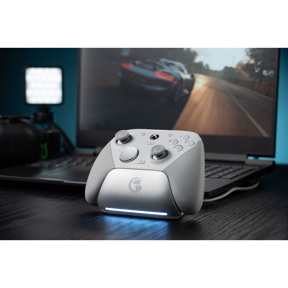 Un controller da gioco di colore chiaro su un supporto con illuminazione blu.