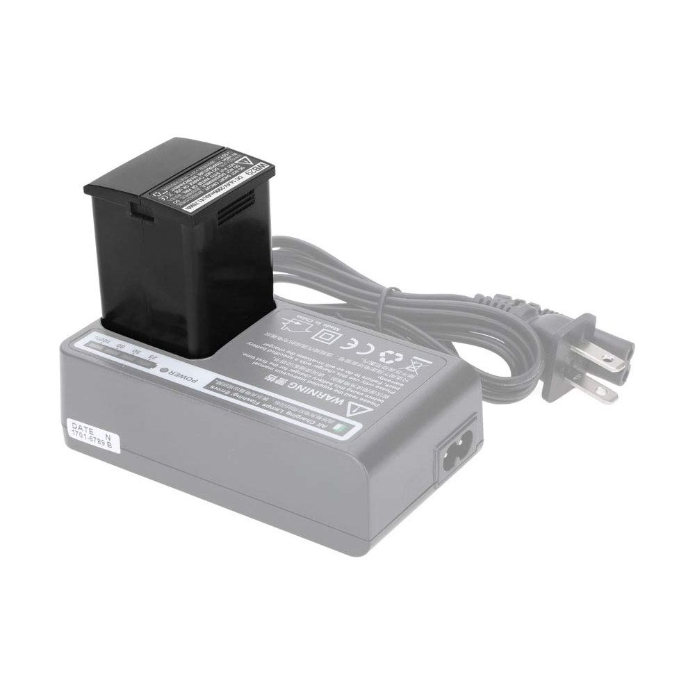 Schwarzer Akku auf einem Ladegerät mit Kabel und Stecker.