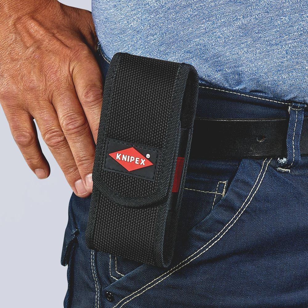 Un uomo indossa una custodia per attrezzi nera con logo KNIPEX sui jeans.