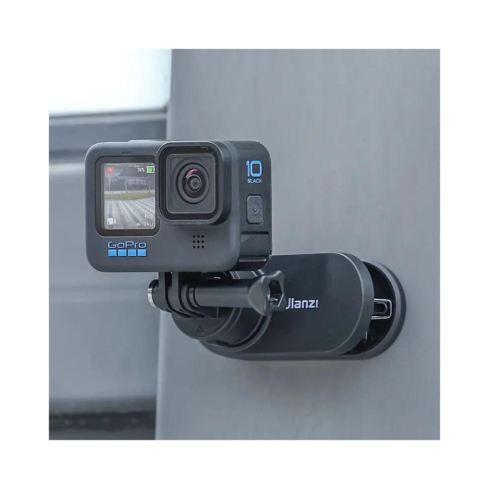 Czarna kamera GoPro z mocowaniem przymocowana do szarej powierzchni.