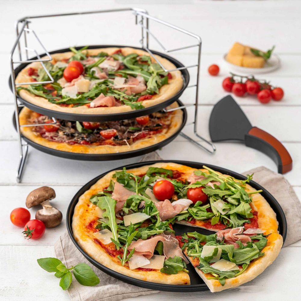 Drei Pizzen auf einem Gestell und auf einem Teller, garniert mit Rucola, Kirschtomaten und Schinken.