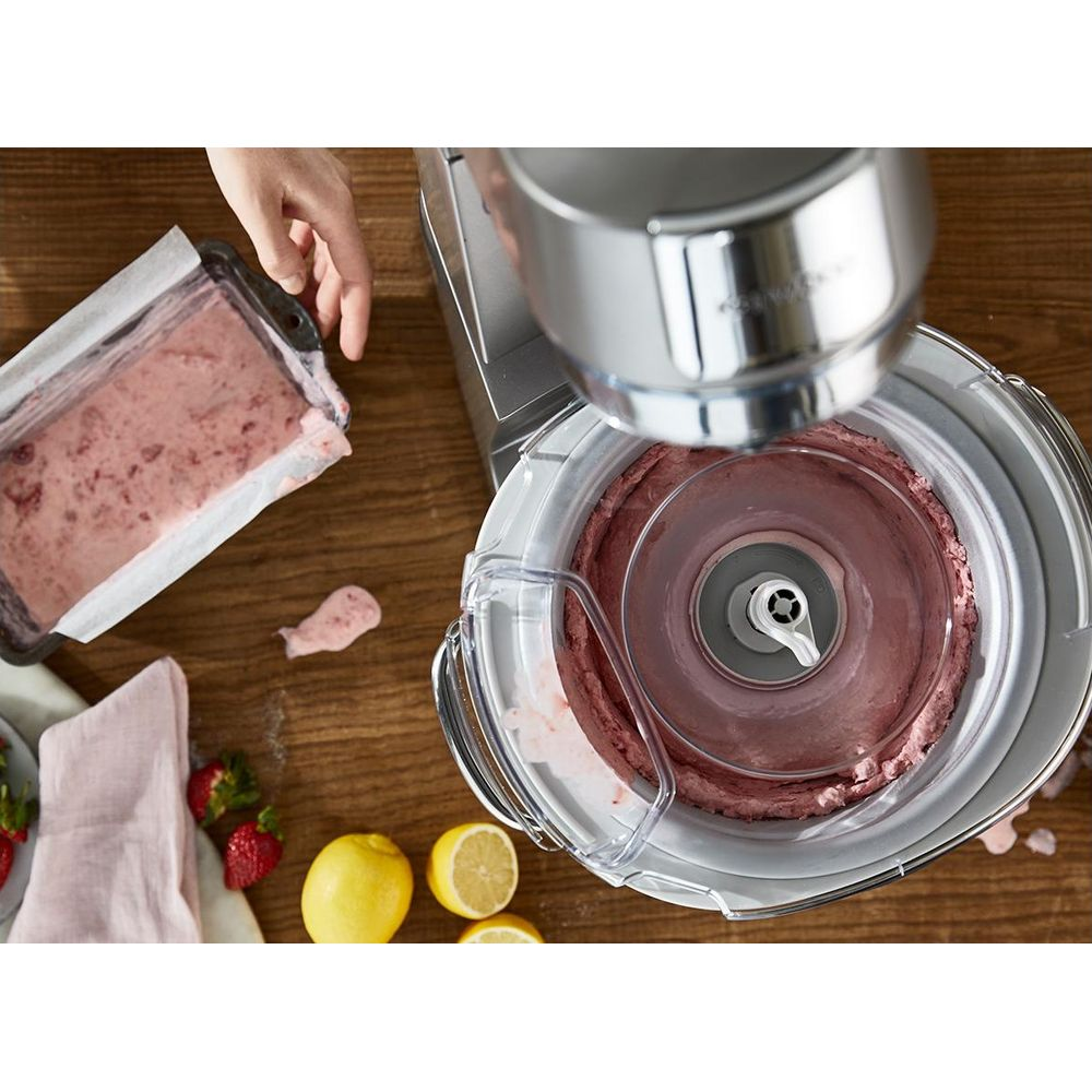 Eisbereiter mit Erdbeer-Eis, Beeren und Zitronen auf Holztisch.