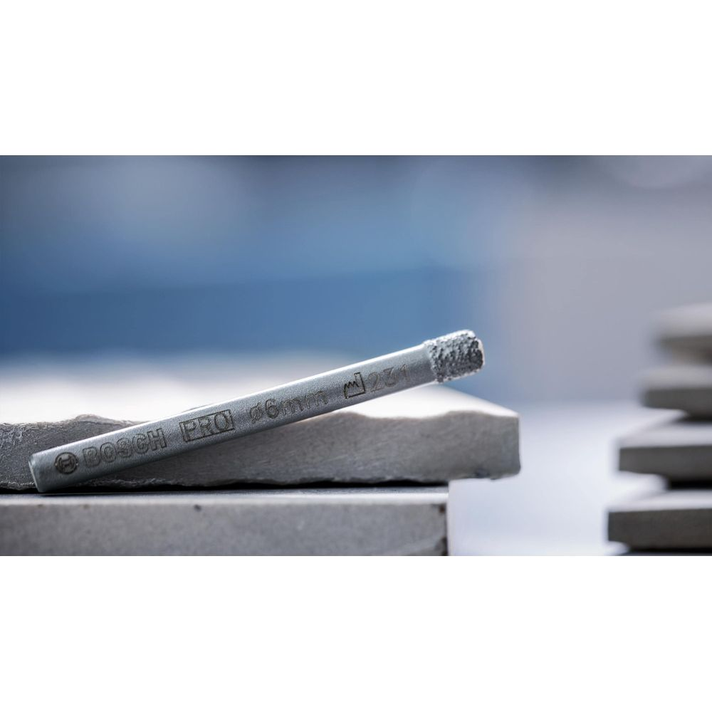 Bosch Pro 6mm Diamantbohrer auf Fliesen, unscharfer Hintergrund.