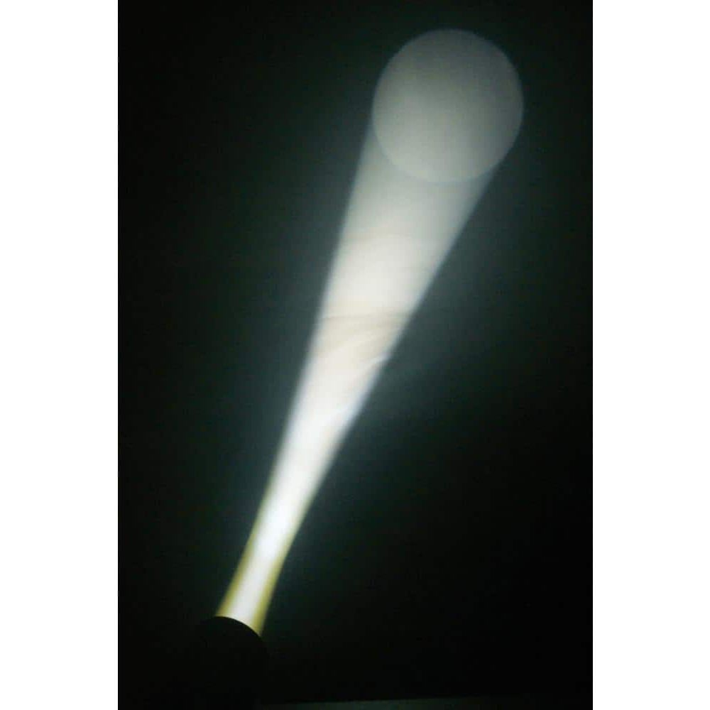 Un brillante haz de luz corta la oscuridad, formando un círculo difuso.