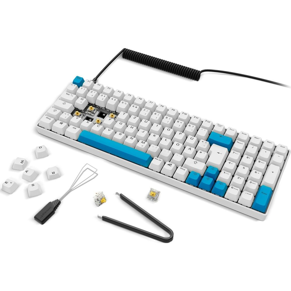 Una tastiera meccanica bianca con tasti blu e accessori.