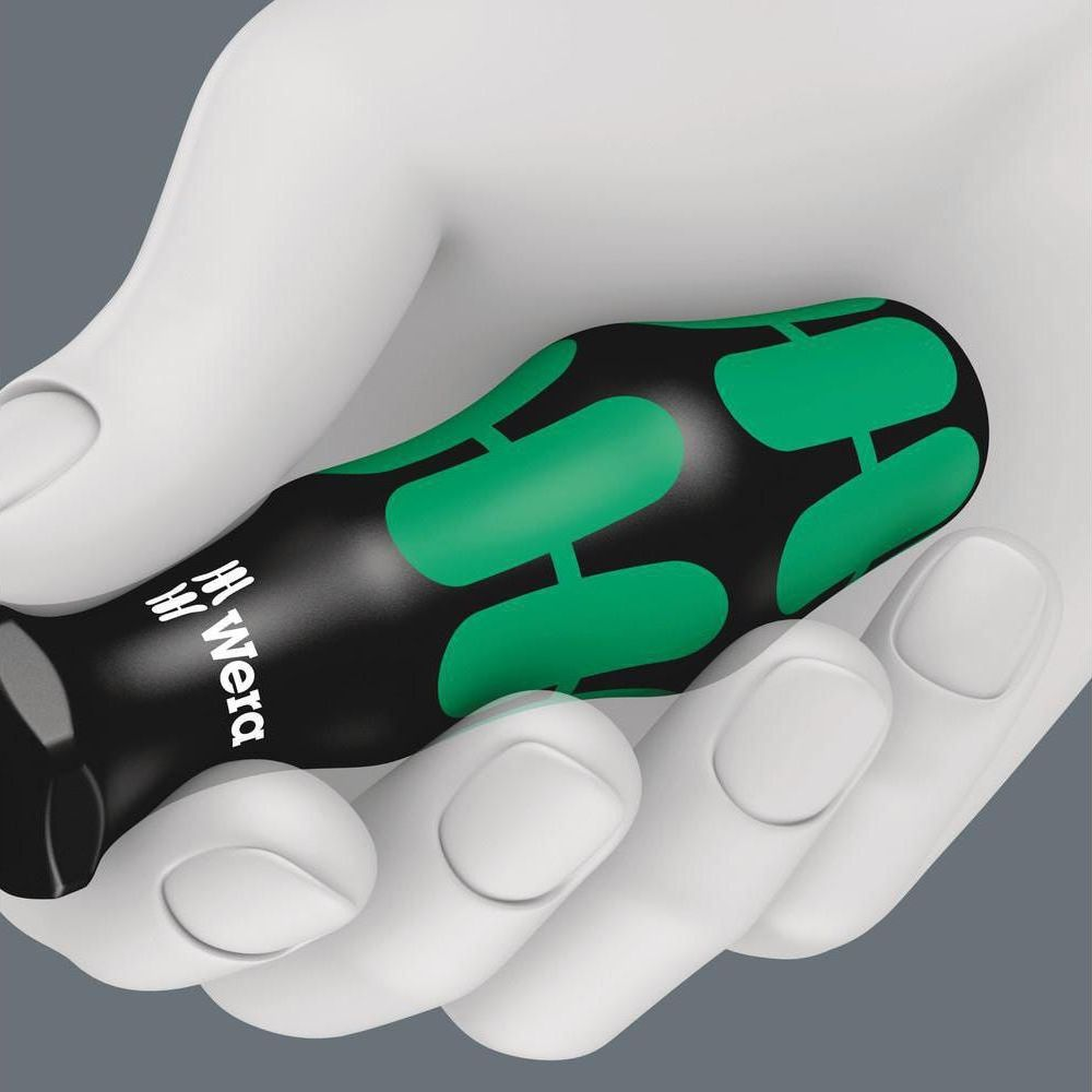 Mano blanca sujetando destornillador negro con detalles verdes.