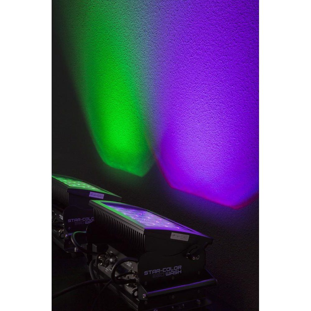 Dos luces de escenario proyectan haces verdes y morados en una pared.