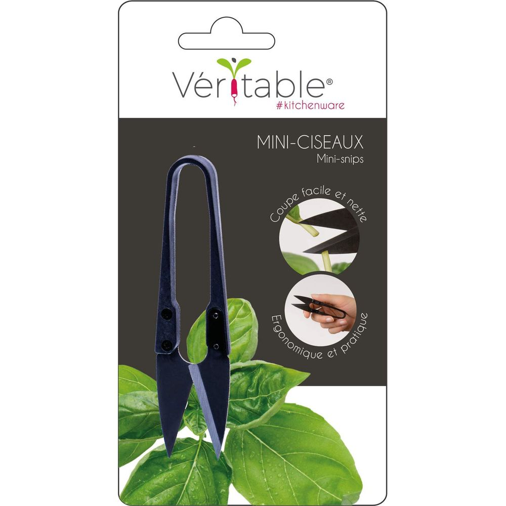 Mini forbici su sfondo scuro con foglie verdi.