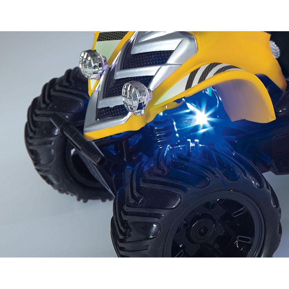 Gelber Monstertruck vorne mit großen schwarzen Reifen und blauen Unterbodenleuchten.