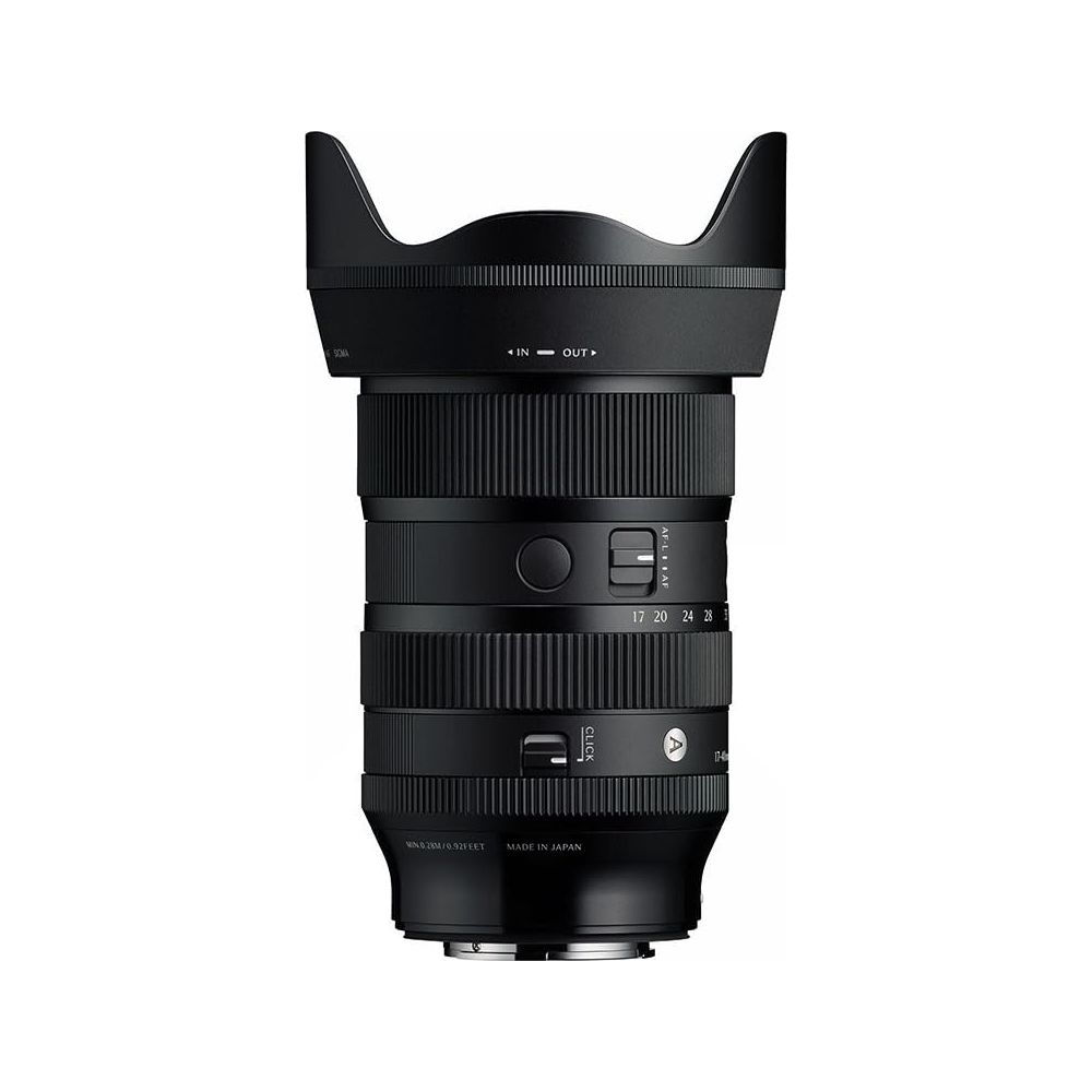 Schwarzes Kameraobjektiv mit Zoomring und Sonnenblende. Beschriftungen: IN/OUT, 17-28, Made in Japan.