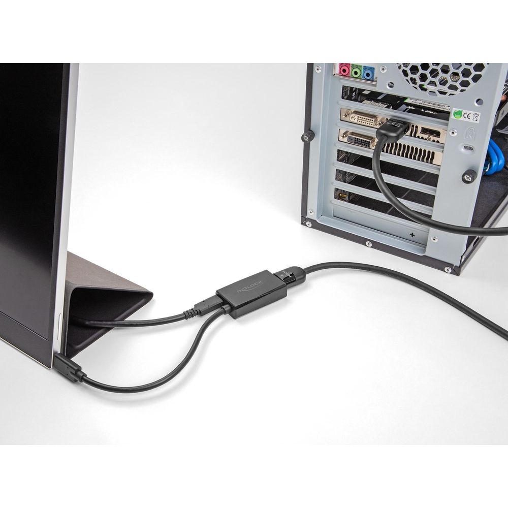 Ein schwarzer Adapter verbindet einen Monitor mit einem Computergehäuse.