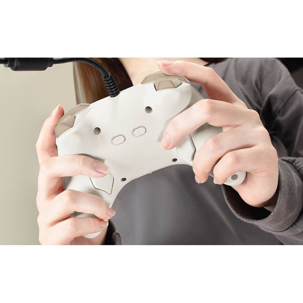 Osoba trzyma biały kontroler. Zbliżenie na dłonie i kontroler.