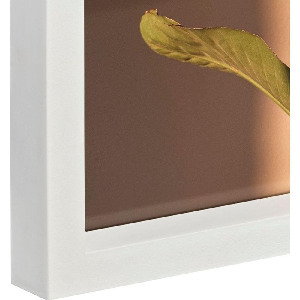 Zielony liść wchodzi w brązowe tło, otoczony białym obramowaniem.