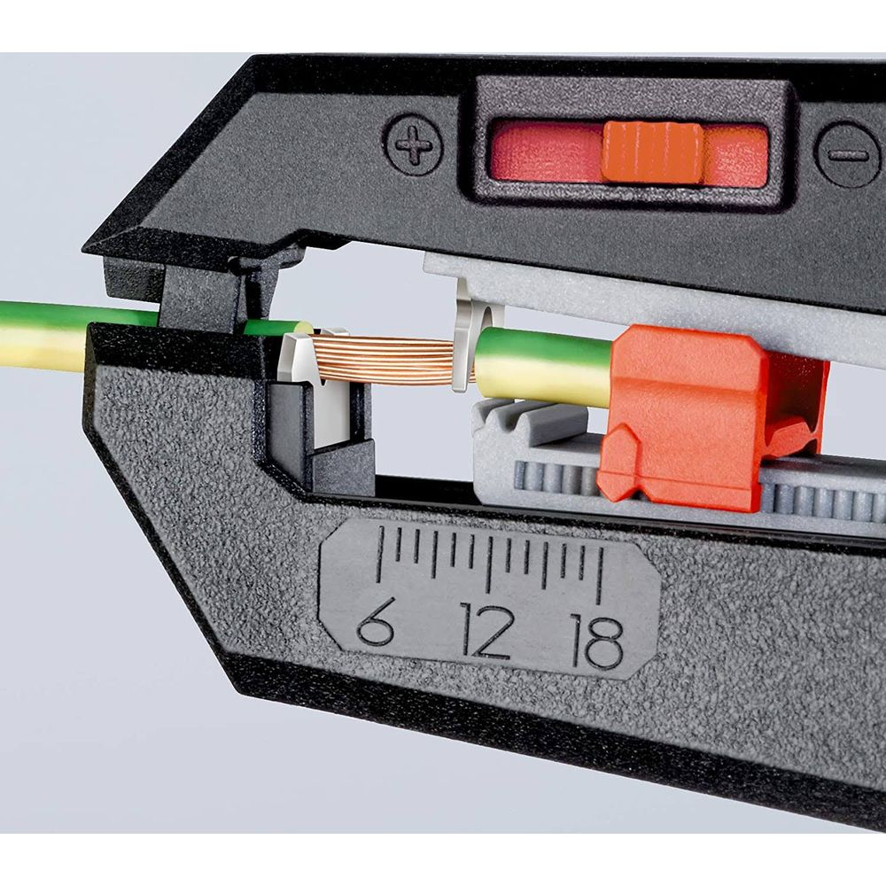 Una herramienta pelacables con un cable verde y amarillo siendo pelado por la cuchilla.