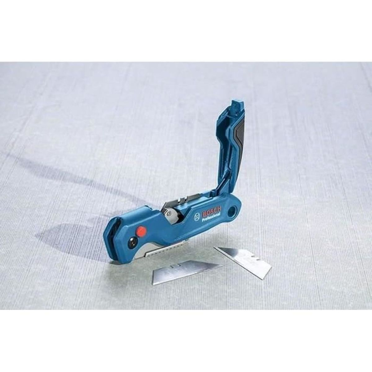 Ein blaues Bosch Klappmesser mit zwei Ersatzklingen auf grauem Untergrund.