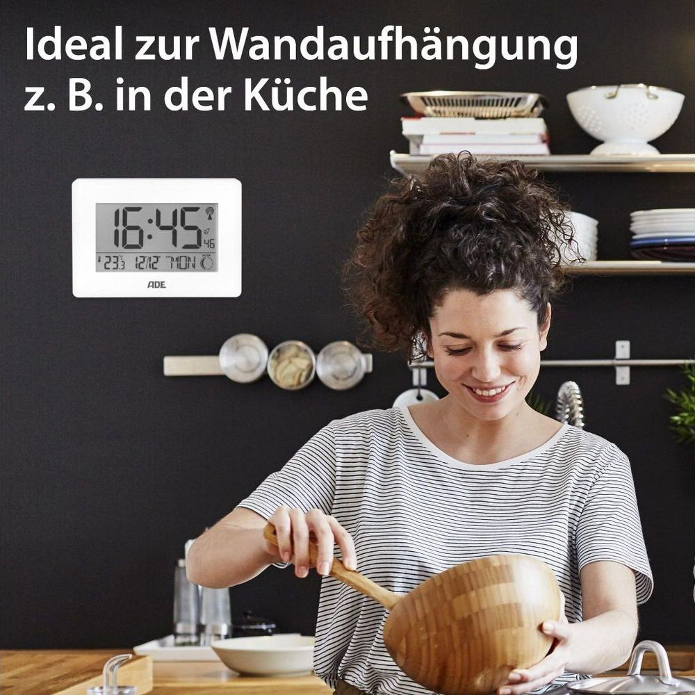 Eine Frau in gestreiftem Shirt hält eine Holzschüssel in einer Küche mit Digitaluhr.