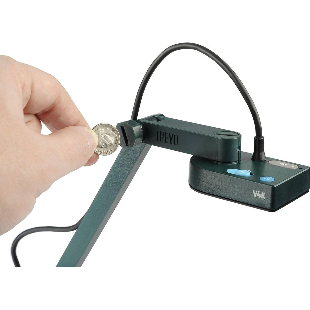 Una mano tiene una moneta accanto a un supporto per fotocamera per documenti IPEVO V4K verde.
