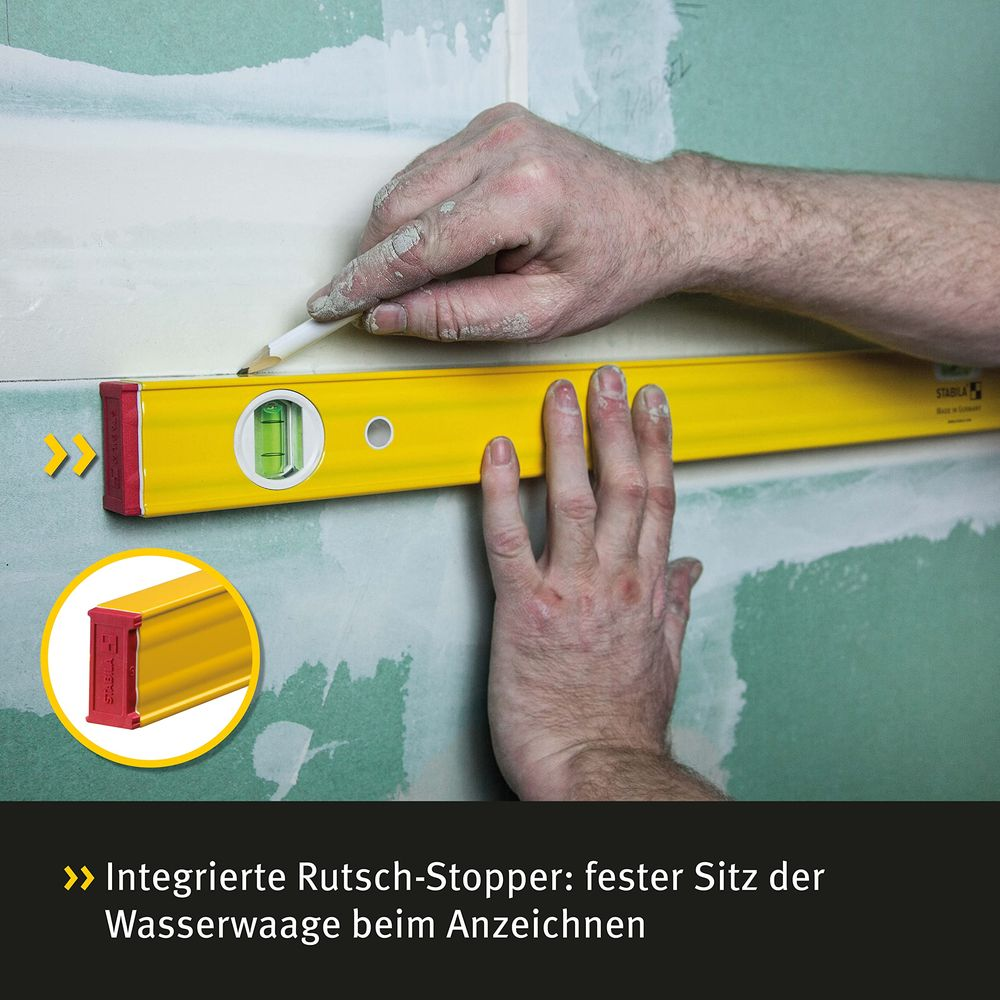 Hände halten eine Wasserwaage an eine Wand, um eine Linie zu markieren.