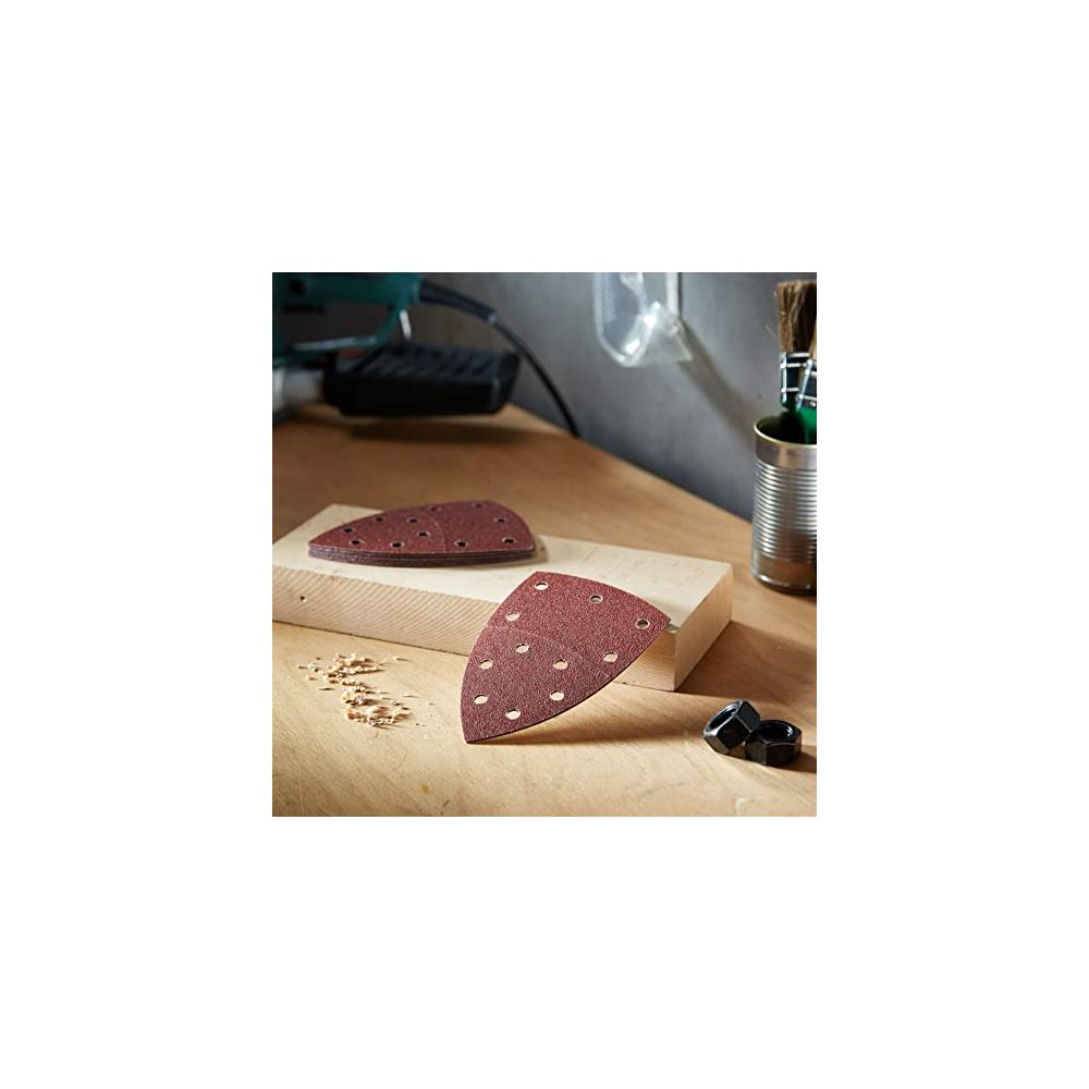 Schleifpapier auf Holz mit Werkzeug im Hintergrund.