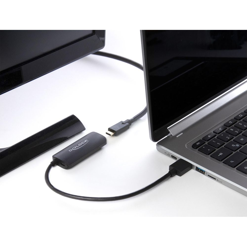 Un portátil se conecta a un monitor a través de un adaptador.
