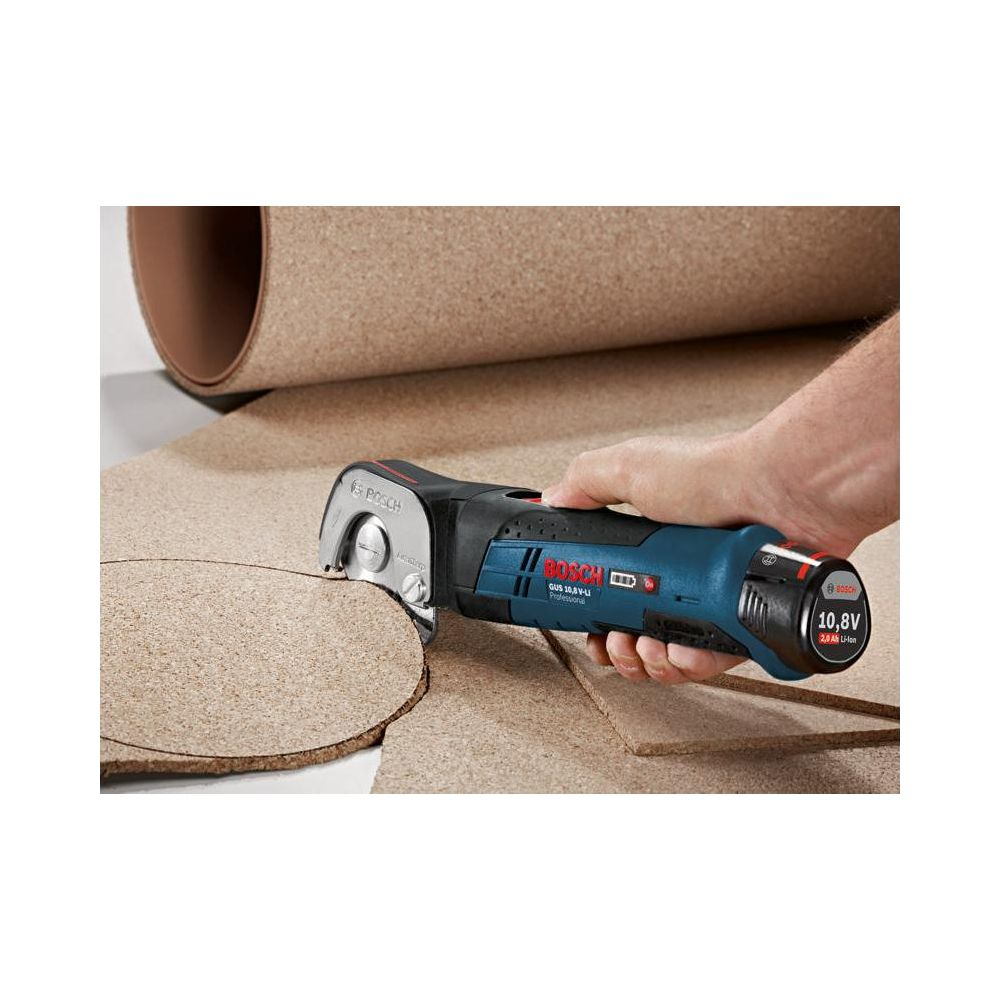 Rzemieślnik tnie kawałek korka niebieskim narzędziem Bosch.