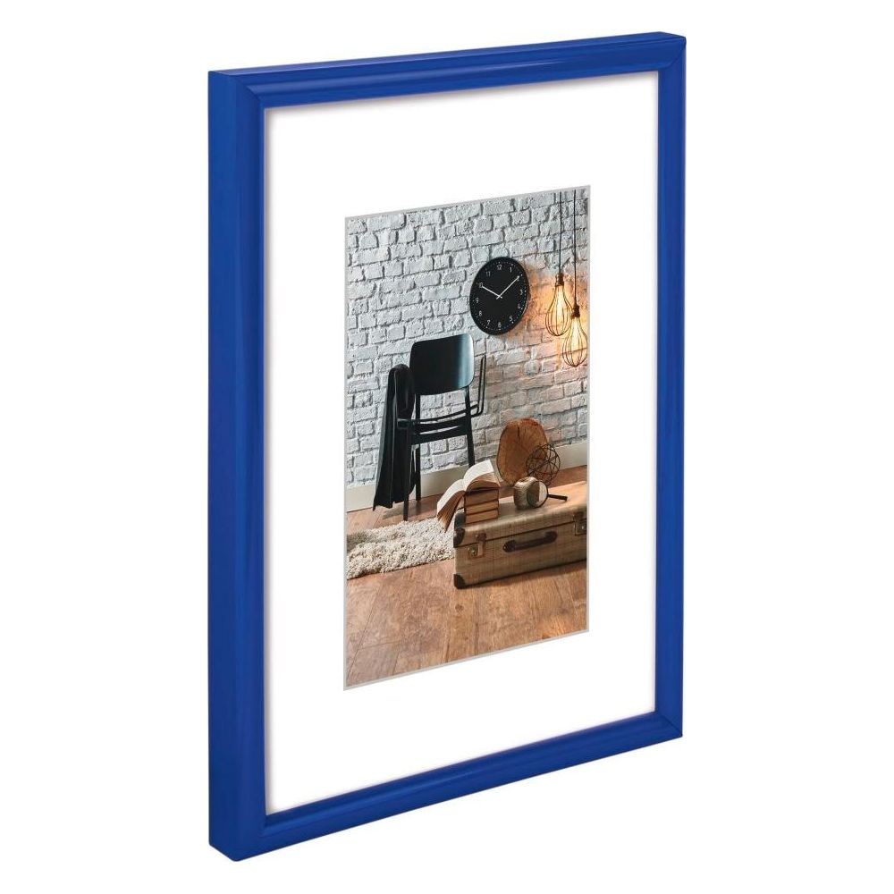Ein blauer Bilderrahmen zeigt ein Interieur mit Stuhl, Uhr, Lampe und Koffer.