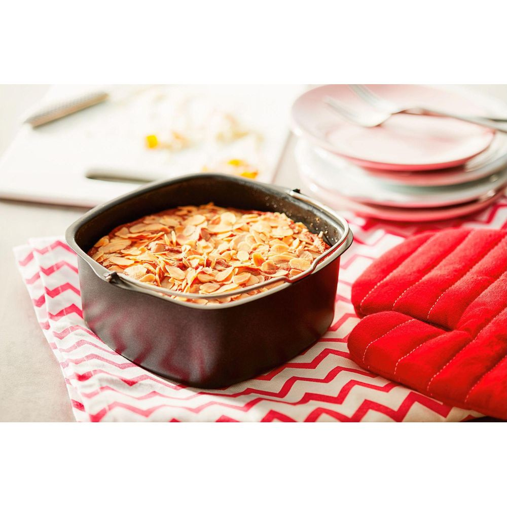 Gâteau fraîchement cuit avec garniture aux amandes dans un moule noir.