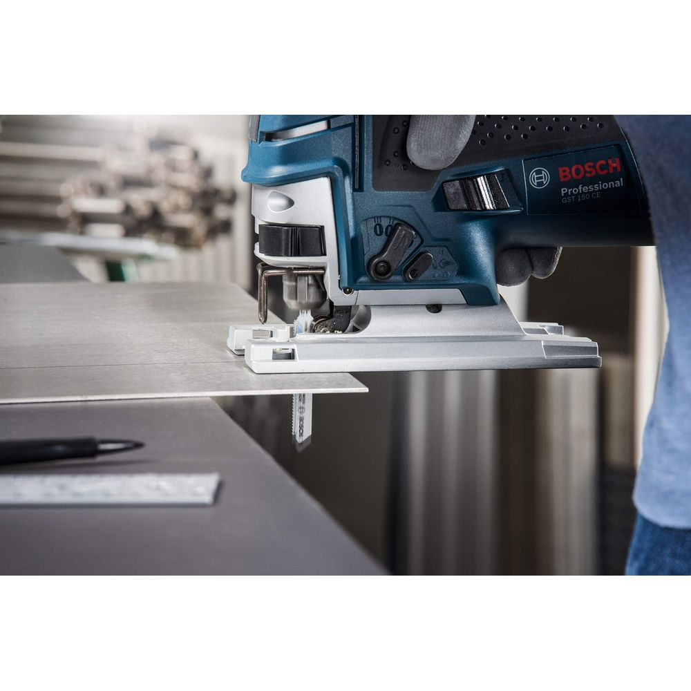 Bosch Stichsäge schneidet Metallplatte, Hände mit Handschuhen halten Werkzeug.