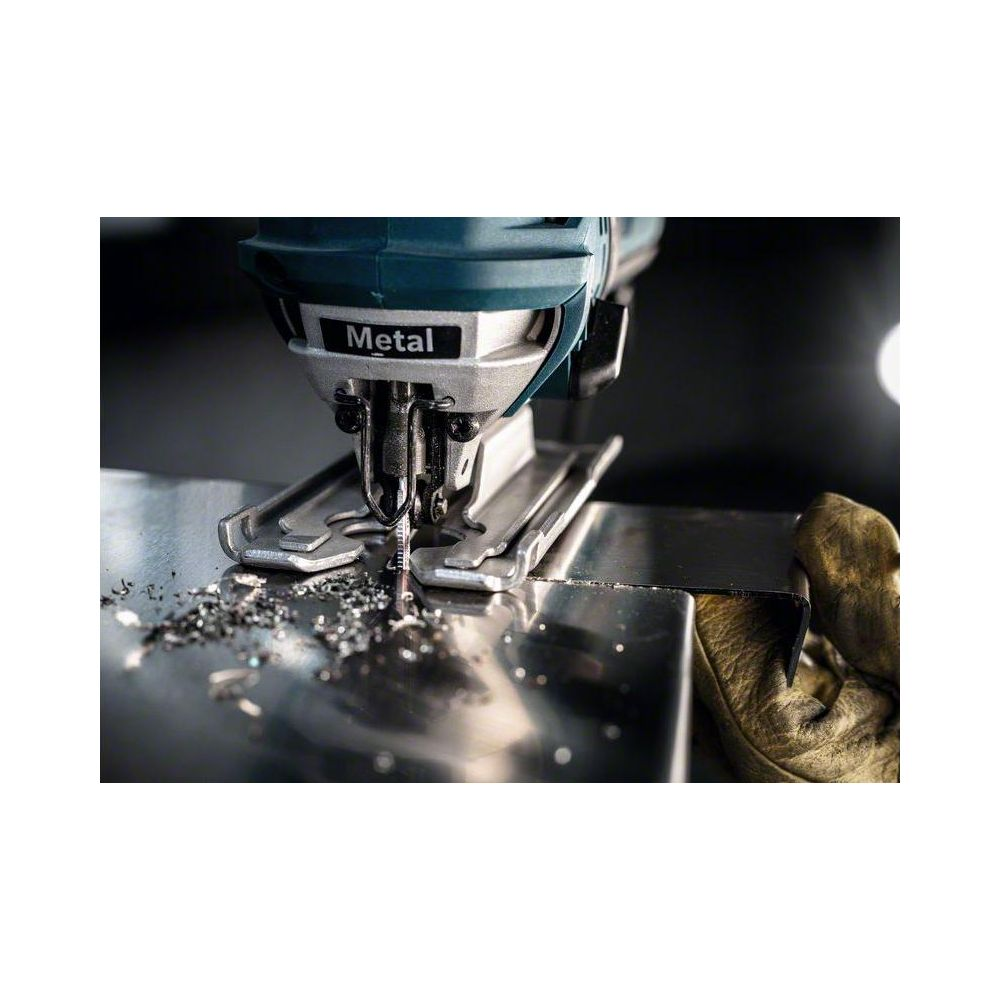 Wyrzynarka tnie metal, rozsypane wióry.