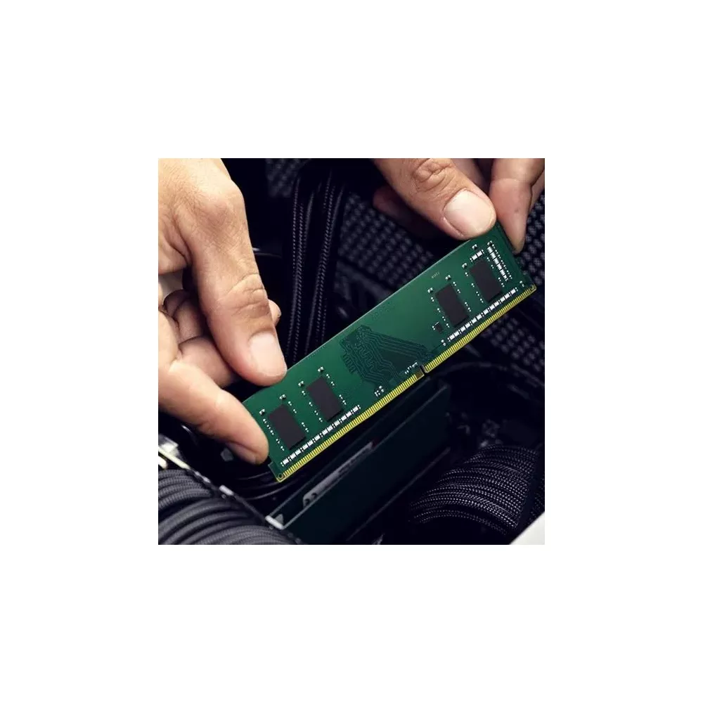 Ręce instalują zielony moduł RAM w komputerze.