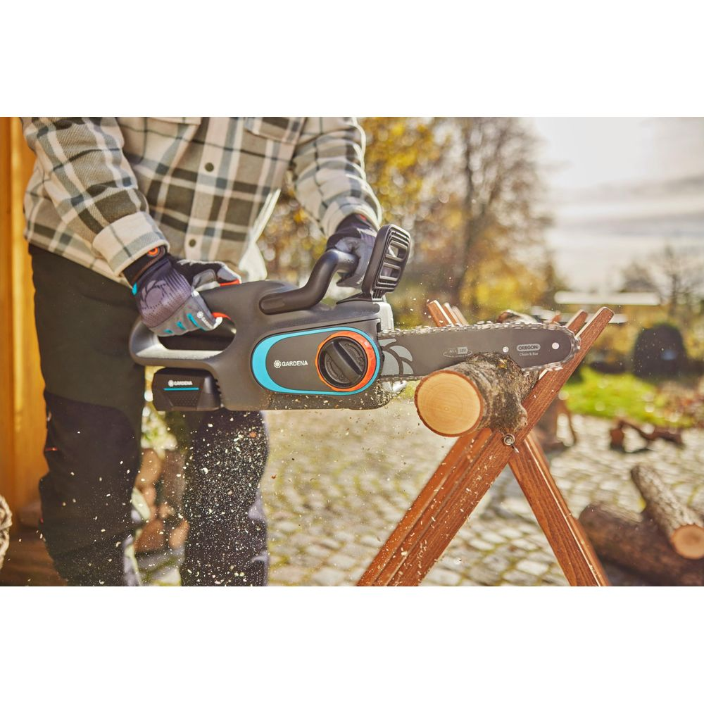 Osoba piuje drewno piłą łańcuchową, lecą trociny.