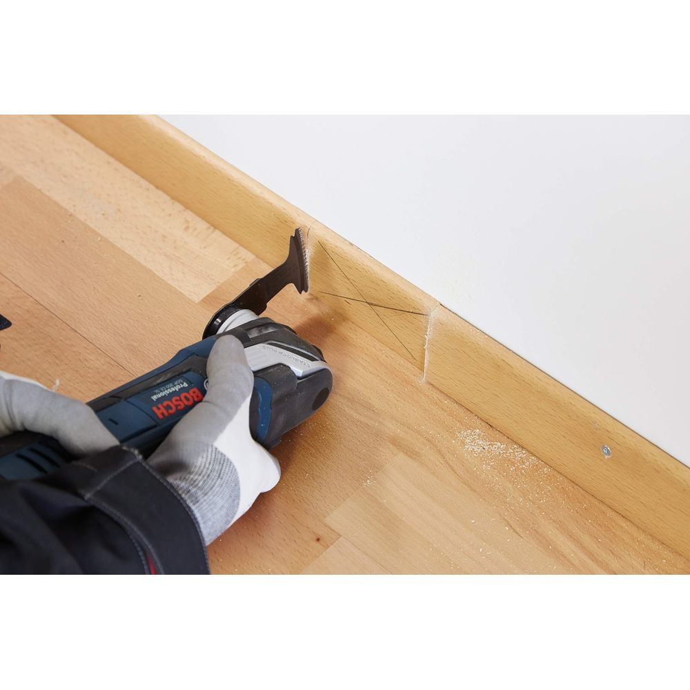 Un attrezzo taglia battiscopa in legno contro un muro. Pavimento in legno.