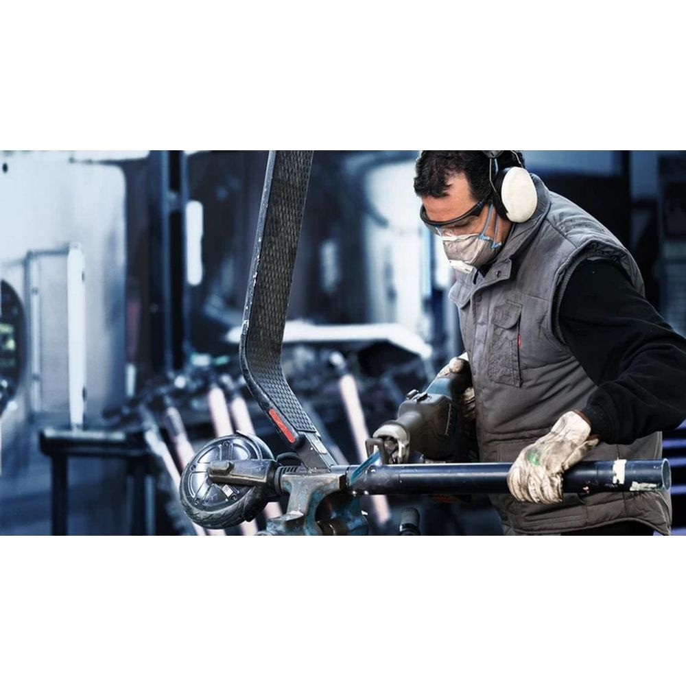 Mężczyzna w goglach i masce pracuje nad skuterem za pomocą narzędzia.