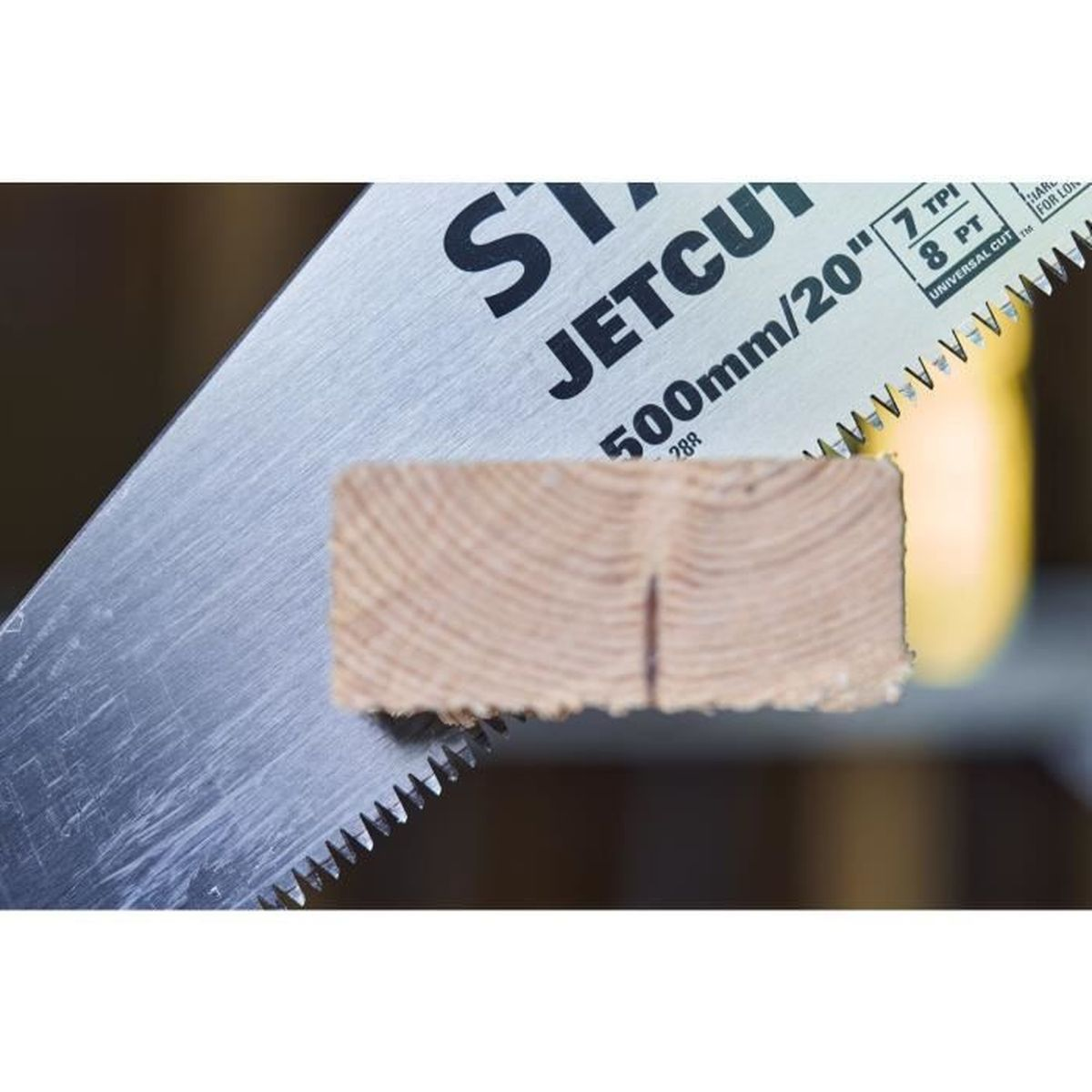 Ręczna piła z napisem "JETCUT" przecina drewniany klocek.