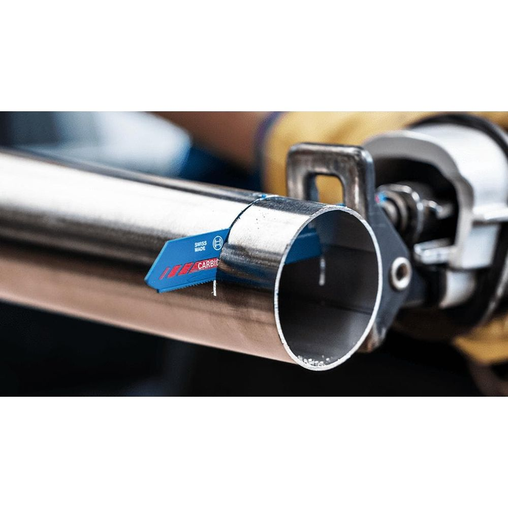 Niebieskie brzeszczoty piły przecinają metalową rurę.