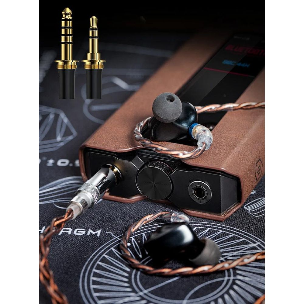 Dos jacks de audio dorados y un reproductor de música portátil marrón con auriculares.
