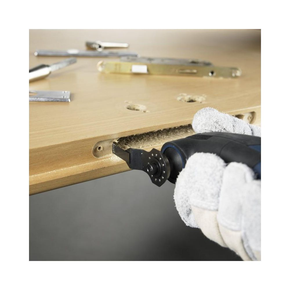 Werkzeug schneidet Holz, Hände mit Handschuhen halten es.