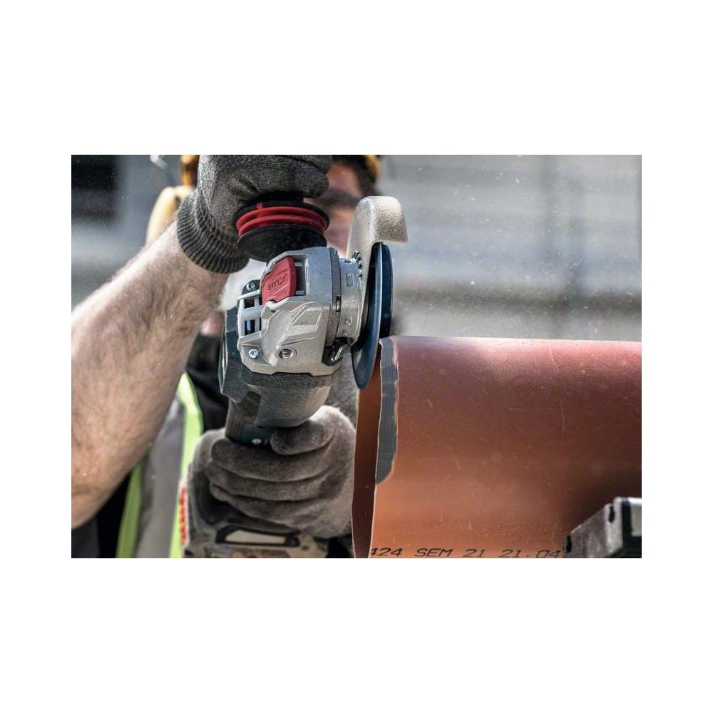 Handwerker schneidet mit Winkelschleifer Rohr. Graue Handschuhe, Schutzbrille.