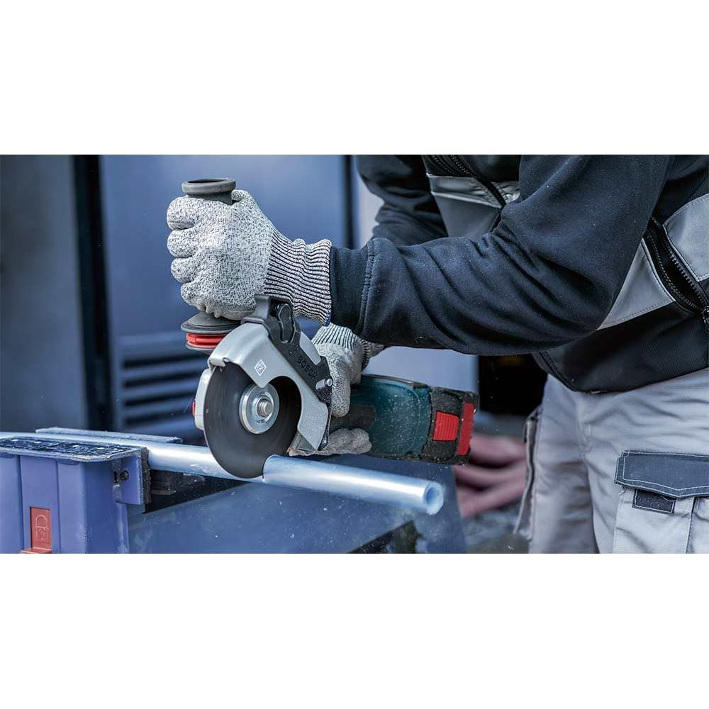 Persona con guantes corta tubo metálico con amoladora, saltan chispas.