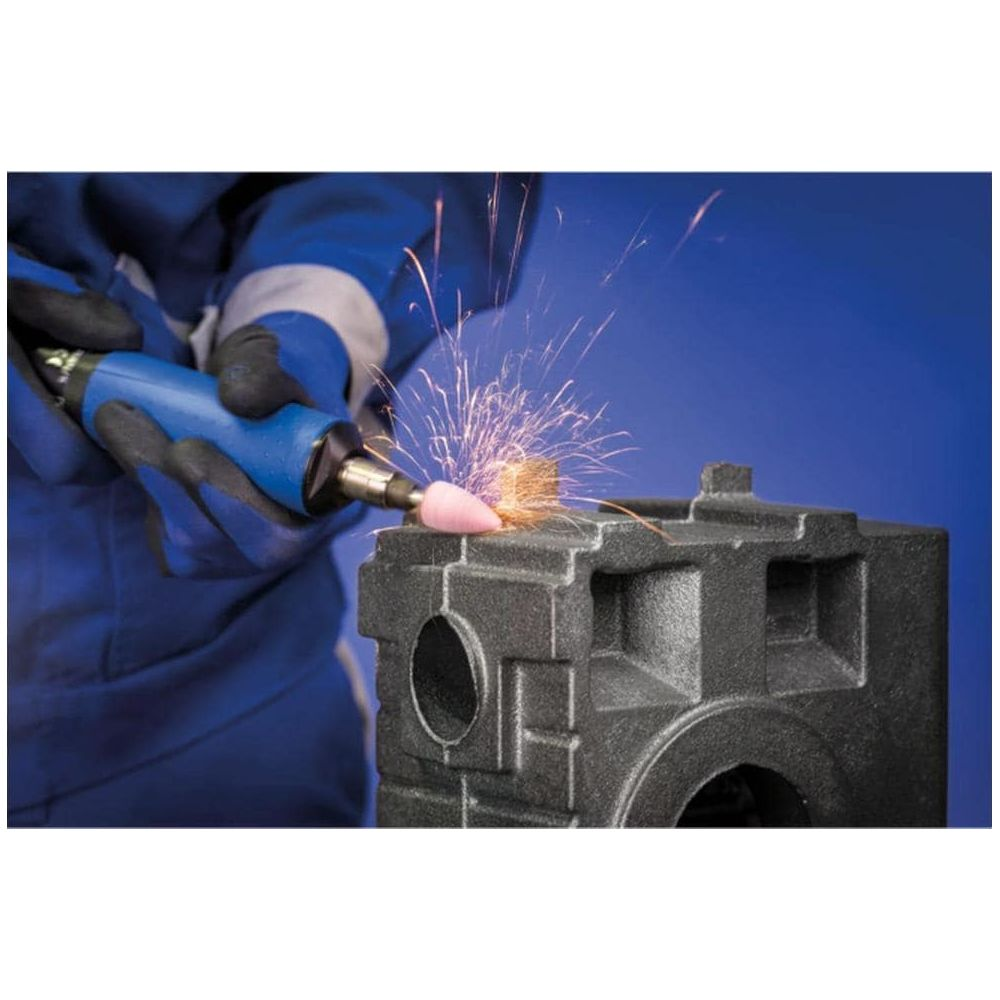 Person schleift dunkles Metallteil mit funkenbildendem Werkzeug.
