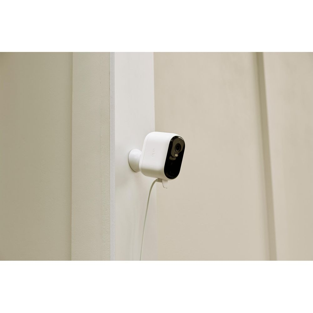 Una telecamera di sicurezza bianca con frontale nero è montata su un muro.